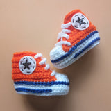 Crochet baby booties in the Converse shoe style in Edmonton Oilers orange. Handmade by Bare It Designs Ltd.