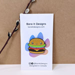 Cute kawaii cheeseburger with eyes and a smile enamel pin on card backing by Bare It Designs