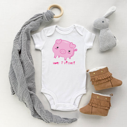 White baby bodysuit with a cute pig drawing in the kawaii art style with the saying Hogs & Kisses for 2019 Year of the Pig. Designed and printed by Bare It Designs.