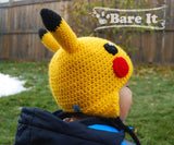 View from the back of the Pokemon Pikachu character crochet toque with ear flaps and braided draw strings. Model is wearing size S toque. Handmade by Bare It Designs Ltd.