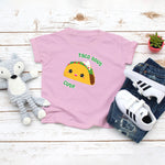 Light pink toddler t-shirt with a cute classic hard shelled taco with the saying "Taco Bout Cute" drawing in the kawaii art style. Designed and printed by Bare It Designs.