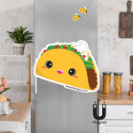 Product picture of a flexible taco fridge magnet with an background example of the taco magnet clinging to a stainless steel fridge. Taco magnet is designed by Bare It Designs.