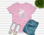 Youth light pink tshirt with a glittery, sparkling unicorn head with pastel purple, pink, and blue mane and eyelashes graphic design. Designed and printed by Bare It Designs.